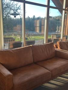 een bruine bank voor een groot raam bij Holmfoss Hytta in Larvik