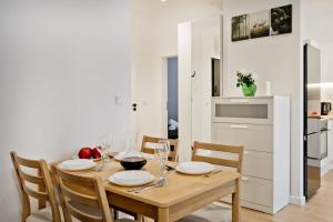 ein Esszimmer mit einem Holztisch und Stühlen in der Unterkunft Apartamenty IN Leśna in Hel + 11 Fotos