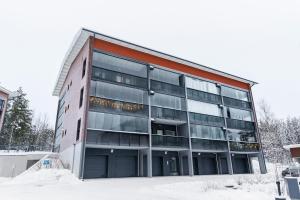 a large glass building with snow in front of it at Luxury Apartment By Lapland Host in Rovaniemi
