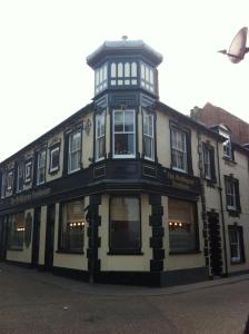 um edifício preto e branco ao lado de uma rua em The Wellington Pub Cromer em Cromer