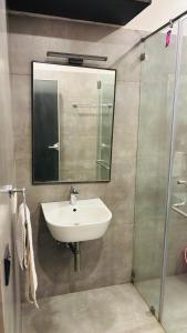 THE SLATE HOTEL NUMGAMBAKKAM Near US EMBASSY & APPOLLO HOSPITAL في تشيناي: حمام مع حوض و مرآة و دش +12 صورة