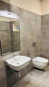 THE SLATE HOTEL NUMGAMBAKKAM Near US EMBASSY & APPOLLO HOSPITAL في تشيناي: حمام مع حوض ومرحاض ومرآة