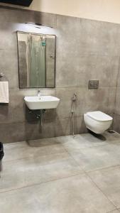 THE SLATE HOTEL NUMGAMBAKKAM Near US EMBASSY & APPOLLO HOSPITAL في تشيناي: حمام مع حوض ومرحاض ومرآة