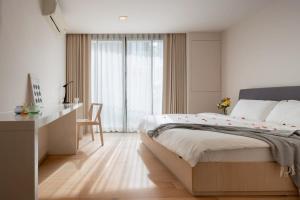 een slaapkamer met een bed, een bureau en een raam bij 2BR2BA BTS Thonglor Rooftop Pool Gym BBQ Low in Bangkok +30 foto's