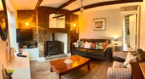 a living room with a couch and a fireplace at Village Cottage Marple in Marple