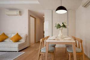 een woonkamer met een tafel en een witte bank bij 2BR2BA BTS Thonglor Rooftop Pool Gym BBQ Low in Bangkok