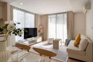 een woonkamer met een bank en een tv bij 2BR2BA BTS Thonglor Rooftop Pool Gym BBQ Low in Bangkok