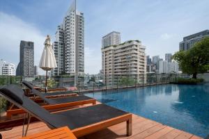 een zwembad met stoelen en een parasol op een gebouw bij 2BR2BA BTS Thonglor Rooftop Pool Gym BBQ Low in Bangkok