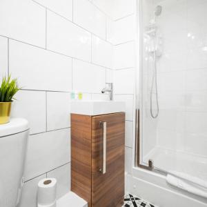 een badkamer met een wastafel en een douche bij Cozy Apartment - Wolverhampton City Centre - Netflix 12AC in Wolverhampton