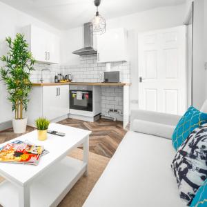 een witte woonkamer met een witte bank en een tafel bij Cozy Apartment - Wolverhampton City Centre - Netflix 12AC in Wolverhampton