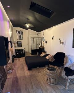 un soggiorno con divano nero e sedie di Apt 35 m2 Baignoire Balnéo terrasse privée a Amfreville-la-Mi-Voie