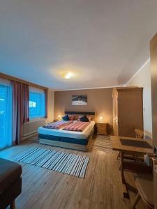 een slaapkamer met een bed en een tafel erin bij Landhaus Tyrol in Mayrhofen