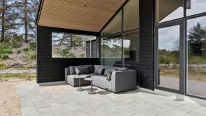 een patio met een bank, een tafel en ramen bij Villavilla #910 - Marielyst, Lollandfalstermøn in Stovby