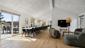 een woonkamer met een lange tafel en stoelen bij Villavilla #910 - Marielyst, Lollandfalstermøn in Stovby