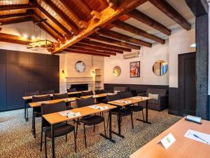 una sala da pranzo con tavoli e sedie in legno di ibis Styles Calais Centre a Calais