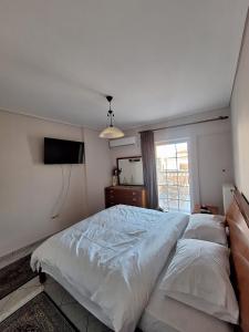 een slaapkamer met een groot bed en een raam bij 4youAPARTMENT in Tríkala