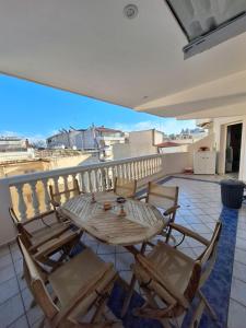 een houten tafel en stoelen op een balkon bij 4youAPARTMENT in Tríkala