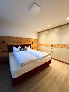 een slaapkamer met een groot bed met witte lakens bij Landhaus Tyrol in Mayrhofen +36 foto's