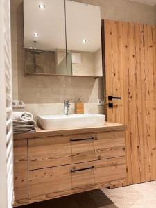 een badkamer met een wastafel en een spiegel bij Landhaus Tyrol in Mayrhofen