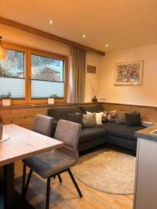 een woonkamer met een bank en een tafel bij Landhaus Tyrol in Mayrhofen