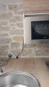 una TV su un muro di pietra accanto a un camino di Luxury suite lilas 5 a Digione