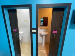 een badkamer met toilet en wastafel en twee deuren bij Sea Side Villa in Ban Pak Khlong Cha-am