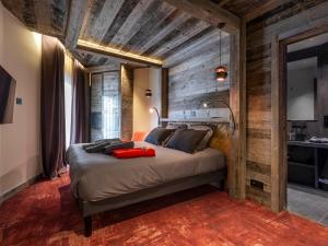 a bedroom with a bed with a wooden wall at Luxueux appartement 6 chambres au cœur d'Avoriaz avec accès spa - FR-1-314-102 in Avoriaz +18 photos