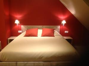 a red bedroom with a bed with two red pillows at Kokkelikoo in Blankenberge