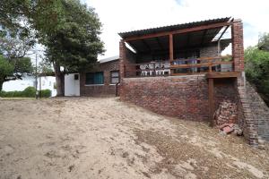 een bakstenen gebouw met een hoop aarde ervoor bij Shalom House in Arniston