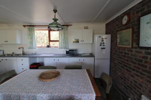 een keuken met een tafel en een keuken met een koelkast bij Shalom House in Arniston +18 foto's