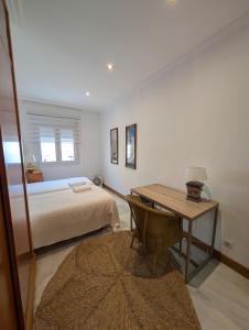 een slaapkamer met een bed, een bureau en een tafel bij Livingtarifa Apartamento El Puerto in Tarifa