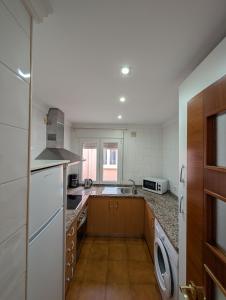 een keuken met een wastafel en een vaatwasser bij Livingtarifa Apartamento El Puerto in Tarifa +9 foto's