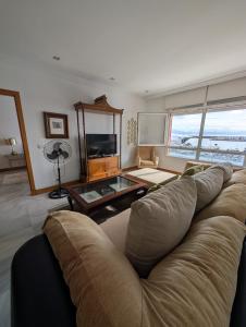 een woonkamer met een bank en een tafel bij Livingtarifa Apartamento El Puerto in Tarifa