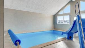 una grande piscina coperta con uno scivolo in una stanza di Villavilla #488 - Mommark, Sydjylland a Sarup