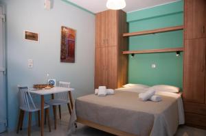 a bedroom with a bed and a table and a desk at GLIPTIS Apartments in Chios