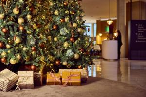 a christmas tree with presents in front of it at Van der Valk Hotel Gent in Ghent