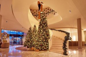 a christmas tree in a lobby with a staircase at Van der Valk Hotel Gent in Ghent
