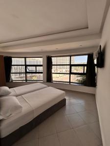 a bedroom with a large bed and large windows at Tanger sun studios in Tangier