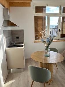 Una cocina con una mesa con un jarrón de flores encima. en Alloggio la lampara, en Campiglia 15 fotos más