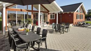 Un patio con mesas y sillas y una sombrilla. en Villavilla #286 - Nordals, Sydjylland, en Nordborg 14 fotos más
