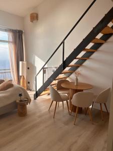 Un dormitorio con una escalera y una mesa y sillas. en Alloggio la lampara, en Campiglia