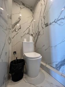 bagno con servizi igienici bianchi in camera di Panoramic Balcony Apartment a Varsavia