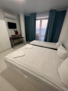 un grande letto bianco in una stanza con una finestra di Panoramic Balcony Apartment a Varsavia