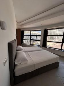 a bedroom with a bed and two large windows at Tanger sun studios in Tangier