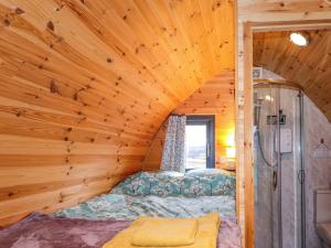 a bed in a room with a wooden ceiling at The Pod at Greenbank in Kilbride +10 photos