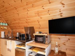 a kitchen with a microwave and a tv on a wall at The Pod at Greenbank in Kilbride