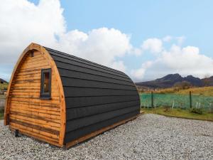 a small wooden cabin with a black roof at The Pod at Greenbank in Kilbride