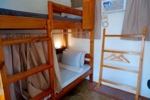 爱妮岛Pugad Hostel, El Nido的房间里有两张双层床，还有梯子