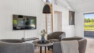 a living room with chairs and a table and a tv at Villavilla #657 - Mommark, Sydjylland in Sarup