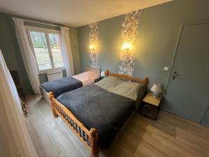 a bedroom with two beds and a window at La maison dans les bois in Crayssac